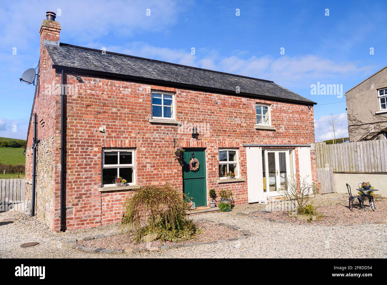 Pretty converted Irish barn house cottage with stable door and sliding barn doors. Stock Photo