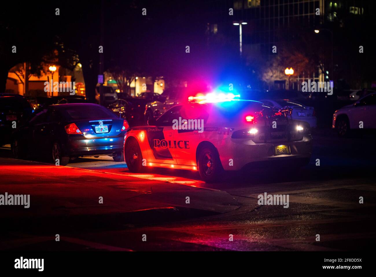 Police car with emergency lights flashing at night in city from the back Stock Photo