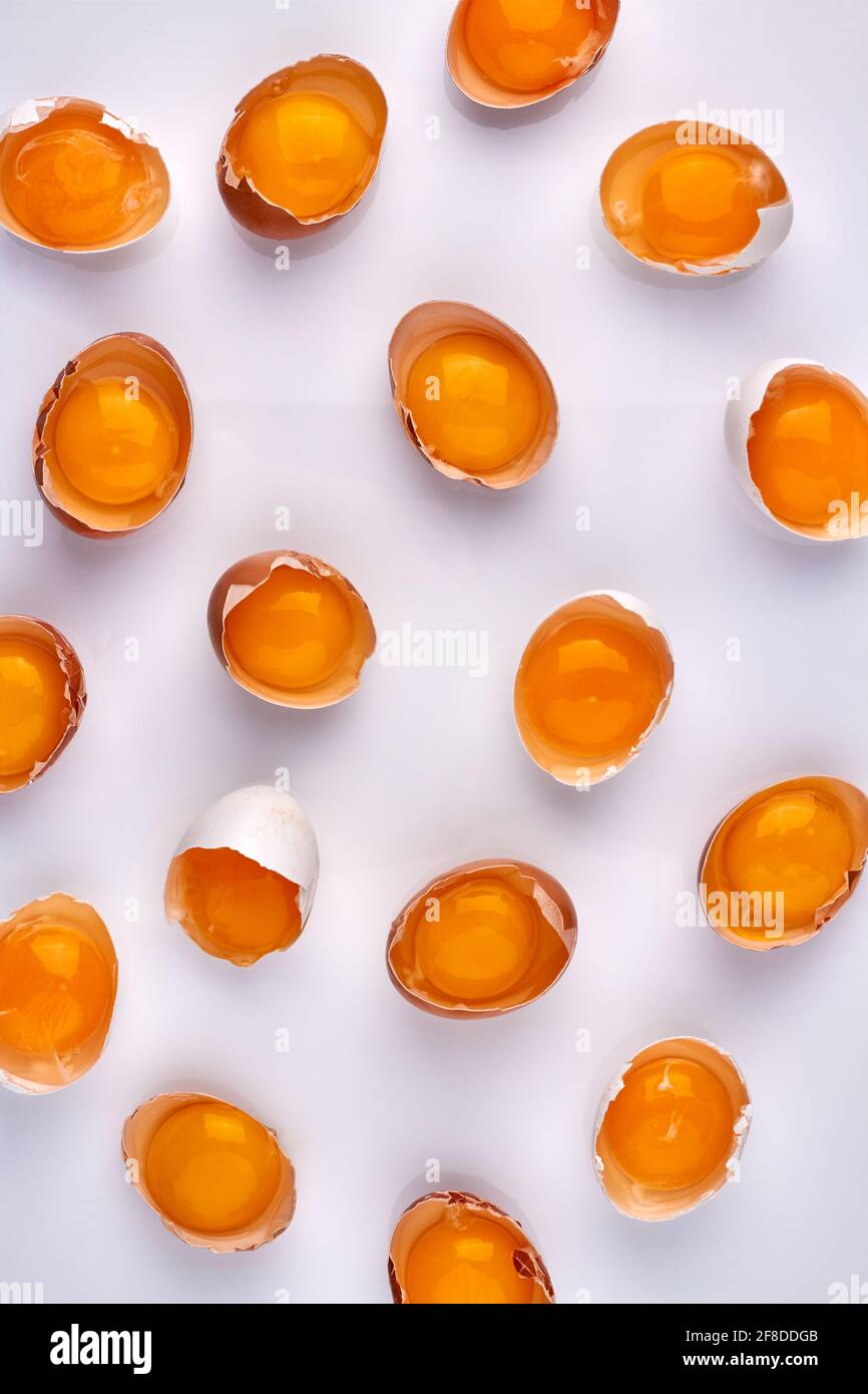 Many cracked eggshells with yolk. Stock Photo