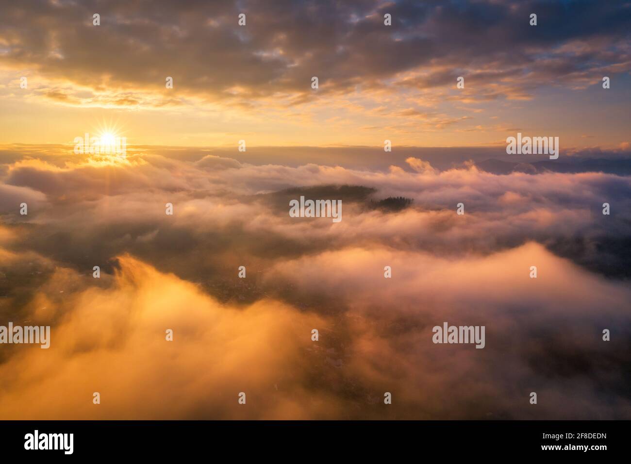 Mountains in clouds at sunrise in summer. Aerial view of mountain peak ...