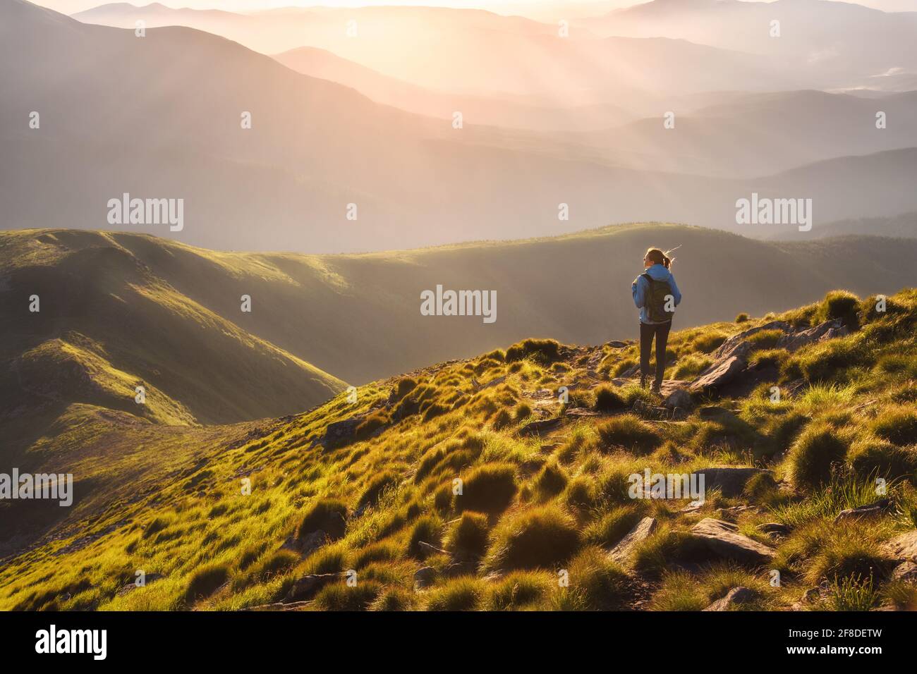 Girl on mountain peak with looking at beautiful mountain valley Stock Photo