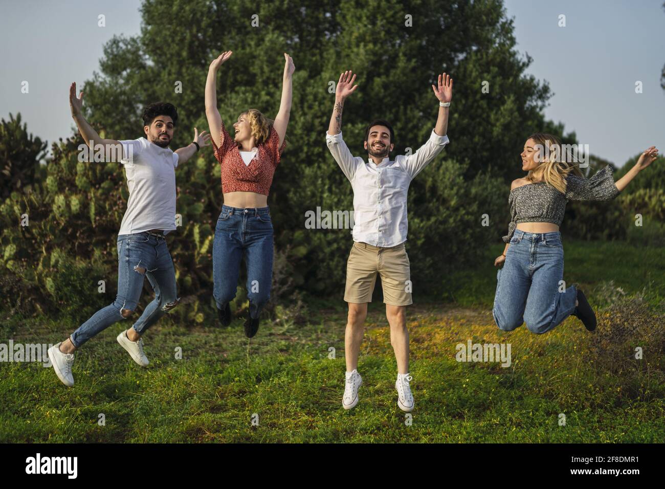 Group of happy friends jumping in a park Stock Photo - Alamy