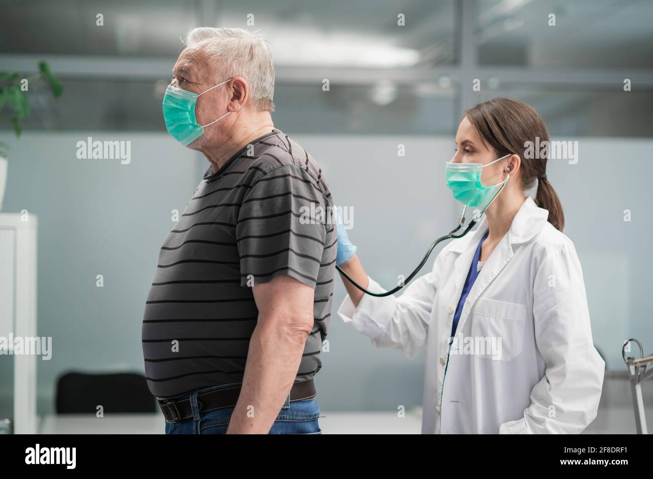 doctor performing lung auscultation with stethoscope on senior