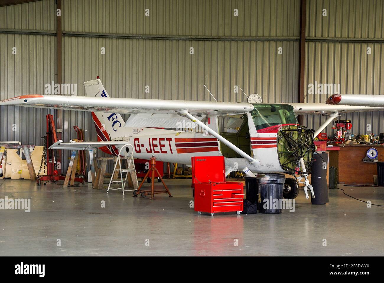 Cessna 152 Aerobat light aircraft G-JEET stripped down for servicing. Heavy maintenance with engine removed. Toolbox Stock Photo