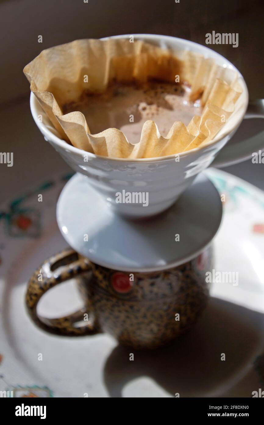 Closeup of a pour over coffee set up as water seeps through ground