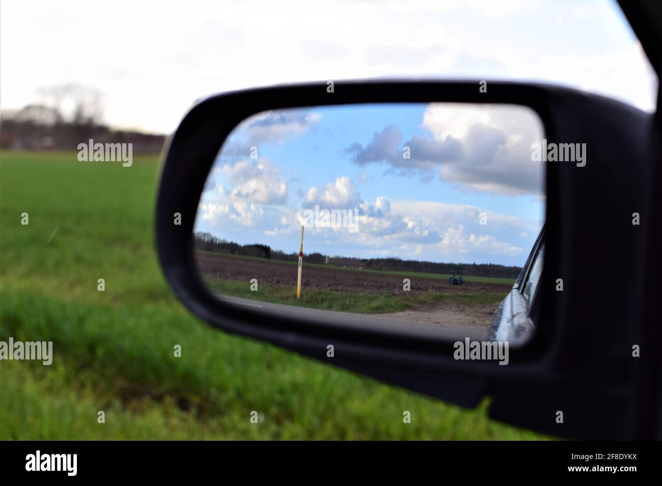 The landscape is reflected in the exterior mirror of a car Stock Photo