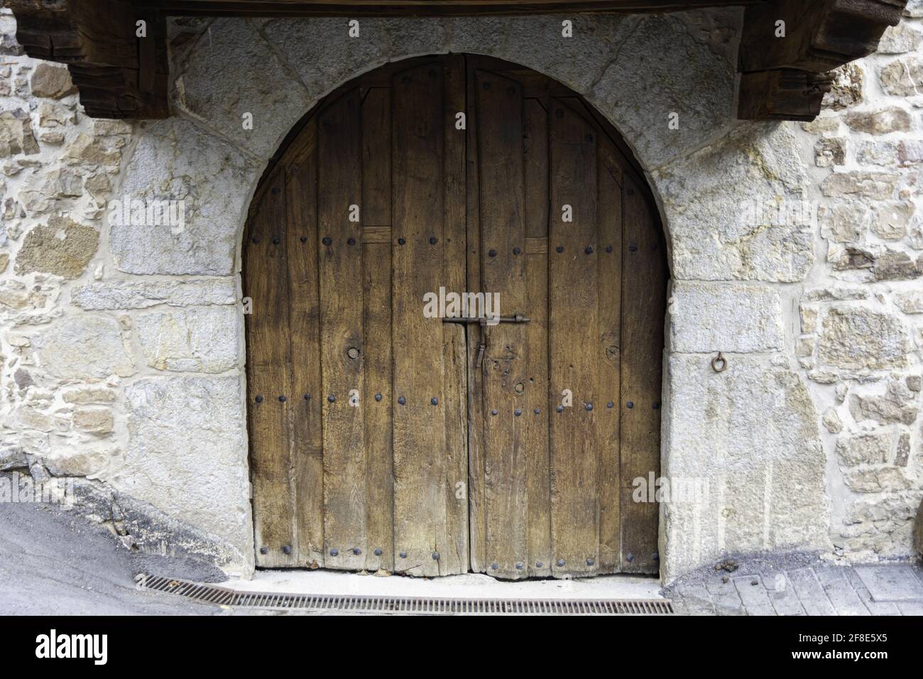 Arched wooden door in a stone wall Stock Photo - Alamy