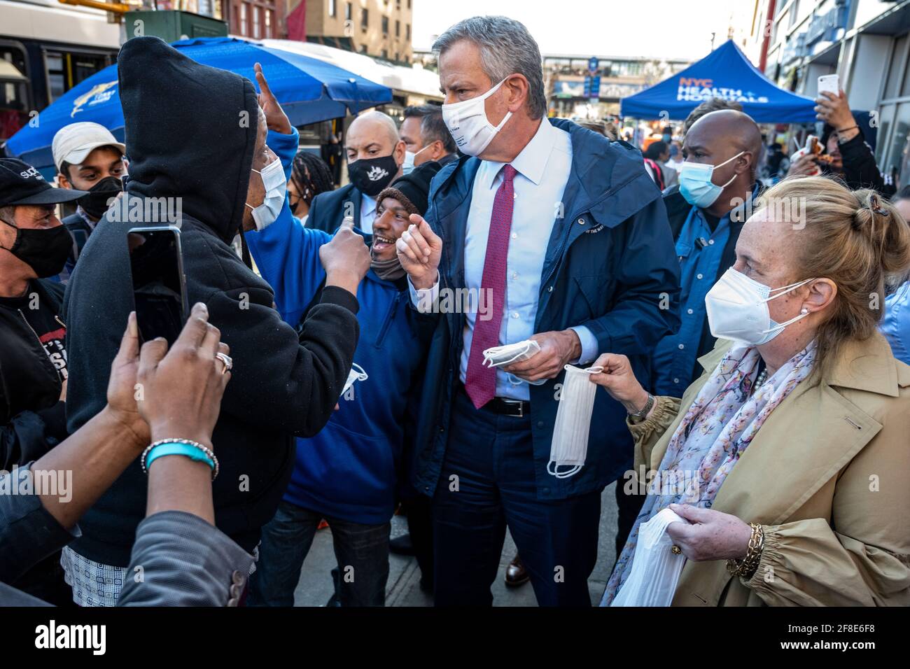 New York, USA. 13th Apr, 2021. New York City's Mayor Bill de Blasio talks to local residents as he joins outreach workers for an event to distribute face masks and set up COVID-19 vaccination appointments in a Spanish Harlem street. Credit: Enrique Shore/Alamy Live News Stock Photo