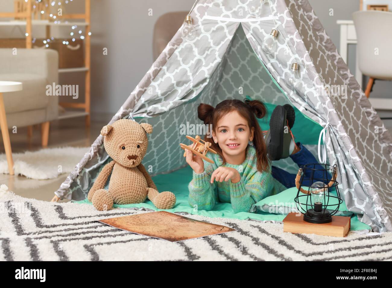 Cute little girl reading book at home Stock Photo - Alamy