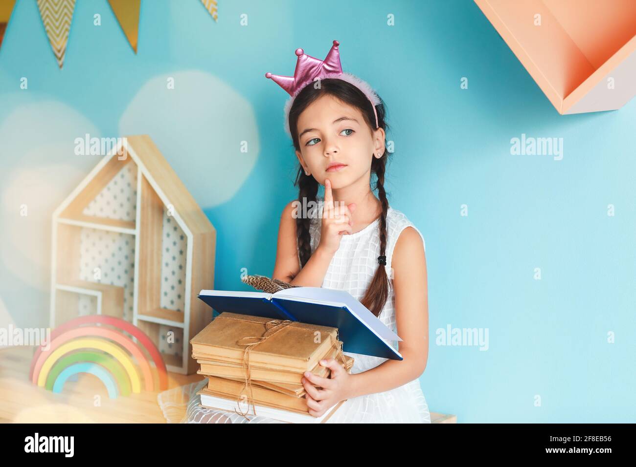 Cute little girl with books at home Stock Photo - Alamy