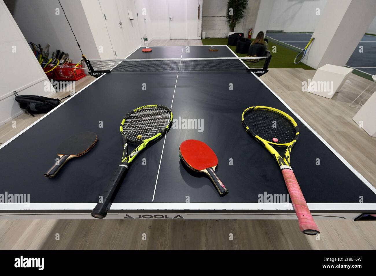 Ping pong paddles and tennis rackets Aree set on a table awaiting kids play time at the Tennis Innovator courts located on 8th Avenue in Midtown Manhattan, New York, NY, April 13, 2021. Equipped with an ION/UV virus killing air ventilation system, the 8,000 square-foot facility offers 4 modified tennis courts with available tennis lessons for adults and children; an “Innovators Move!” program offers time for children to play multiple types of ball games, including basketball, table tennis and tennis, centered around developing strength and coordination. (Photo by Anthony Behar/Sipa USA) Stock Photo