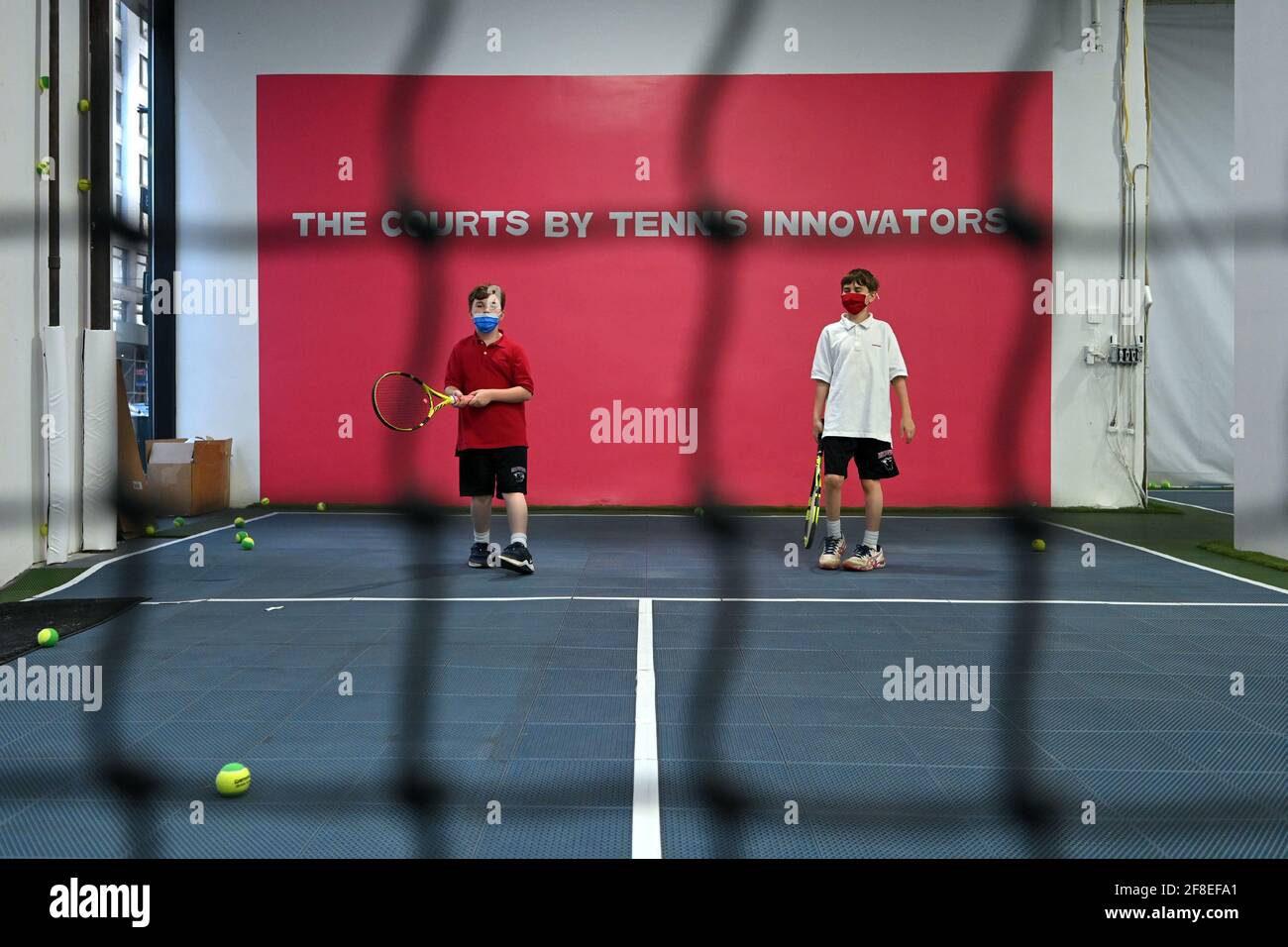 (L R) Brothers Matthew 8 and Edward 9 participate in a tennis lesson