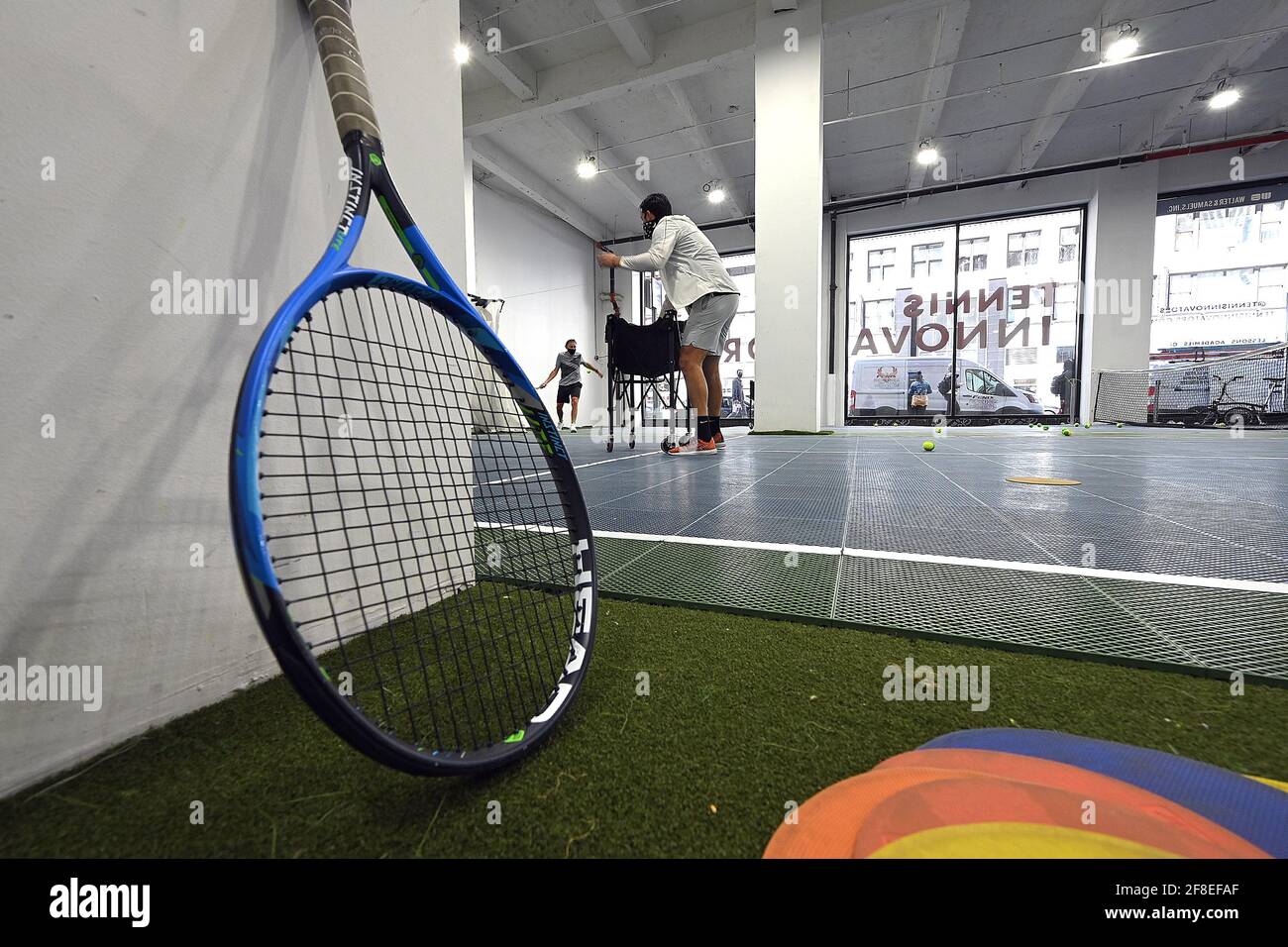 People participate in tennis lessons at the Tennis Innovator courts located on 8th Avenue in Midtown Manhattan, New York, NY, April 13, 2021. Equipped with an ION/UV virus killing air ventilation system, the 8,000 square-foot facility offers 4 modified tennis courts with available tennis lessons for adults and children; an “Innovators Move!” program offers time for children to play multiple types of ball games, including basketball, table tennis and tennis, centered around developing strength and coordination. (Photo by Anthony Behar/Sipa USA) Stock Photo