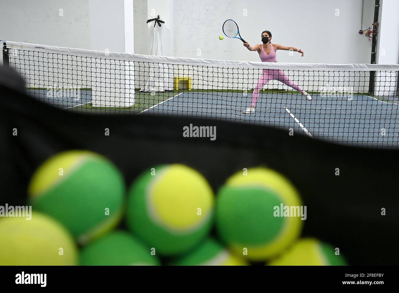 Marielle Halper hits tennis balls while being coached at the Tennis  Innovator courts located on 8th Avenue in Midtown Manhattan, New York, NY,  April 13, 2021. Equipped with an ION/UV virus killing