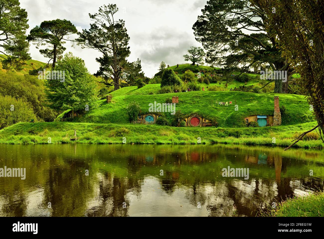 In the heart of Hamilton & Waikato’s countryside, quietly hidden behind green rolling hills, is a place unlike any other – Hobbiton Movie Set; the per Stock Photo