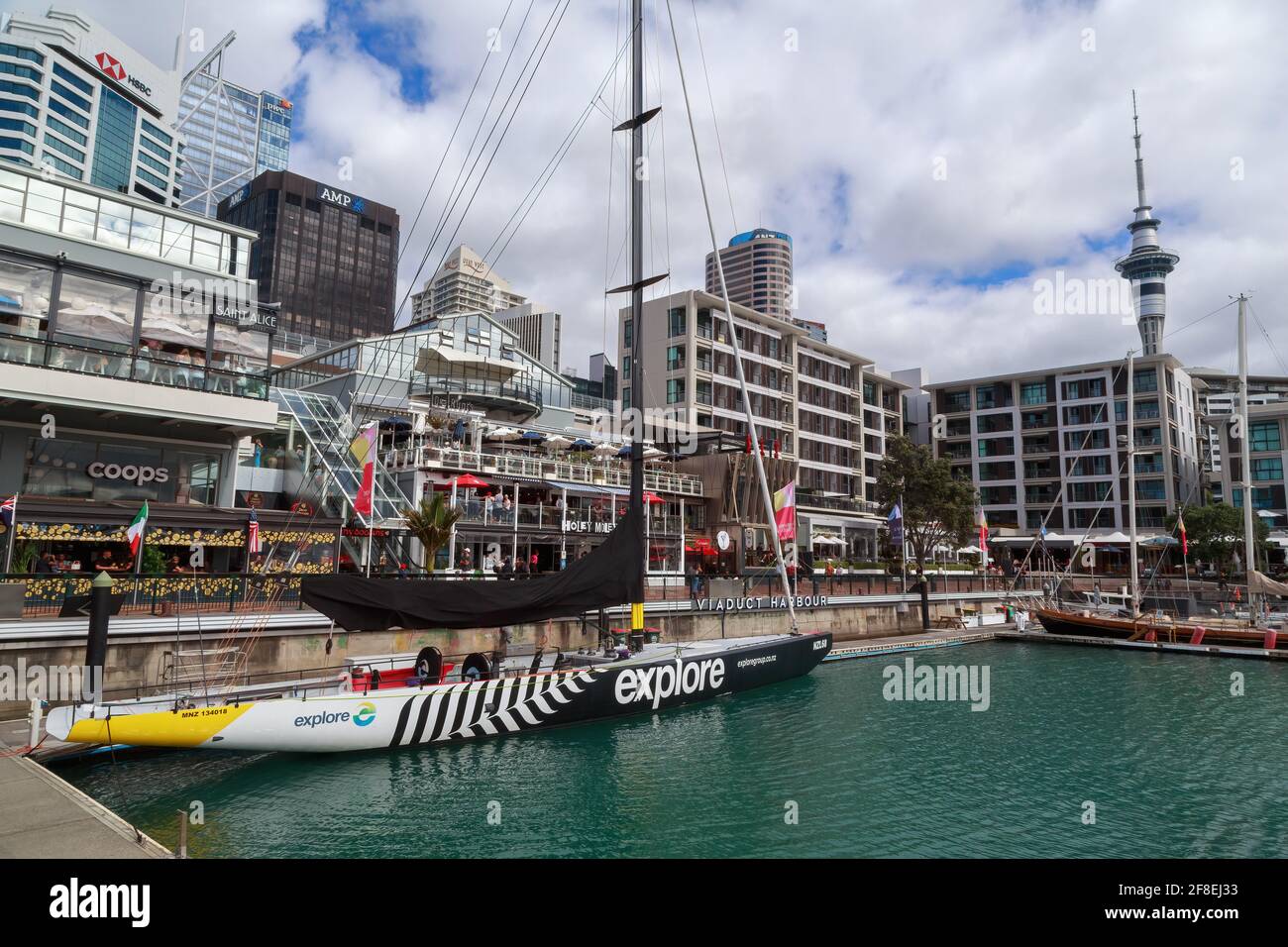 Viaduct Harbour, Auckland, New Zealand. On the water is the yacht NZL 68, a former America's Cup training boat Stock Photo