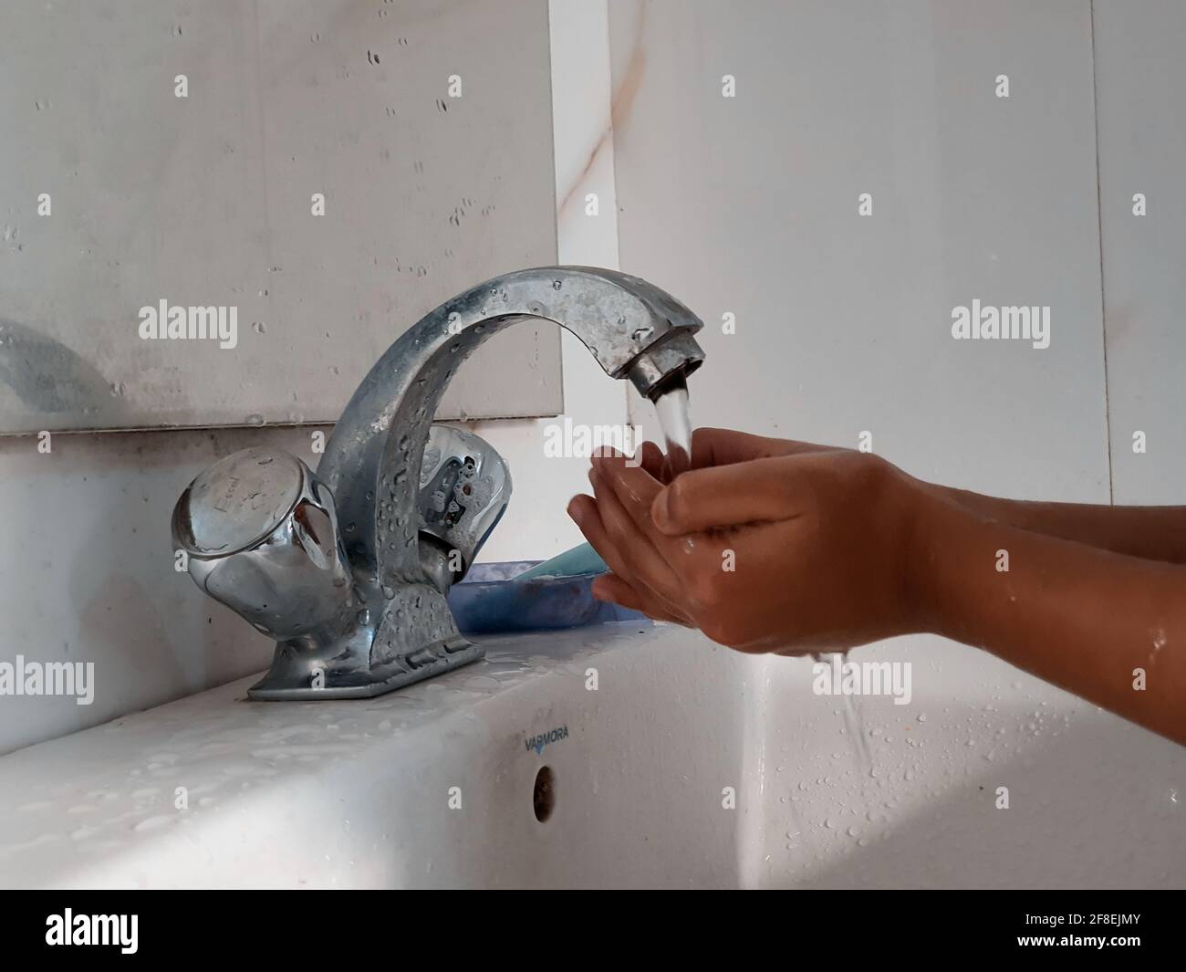 Masked kids washing hands during coronavirus lock down in india Stock