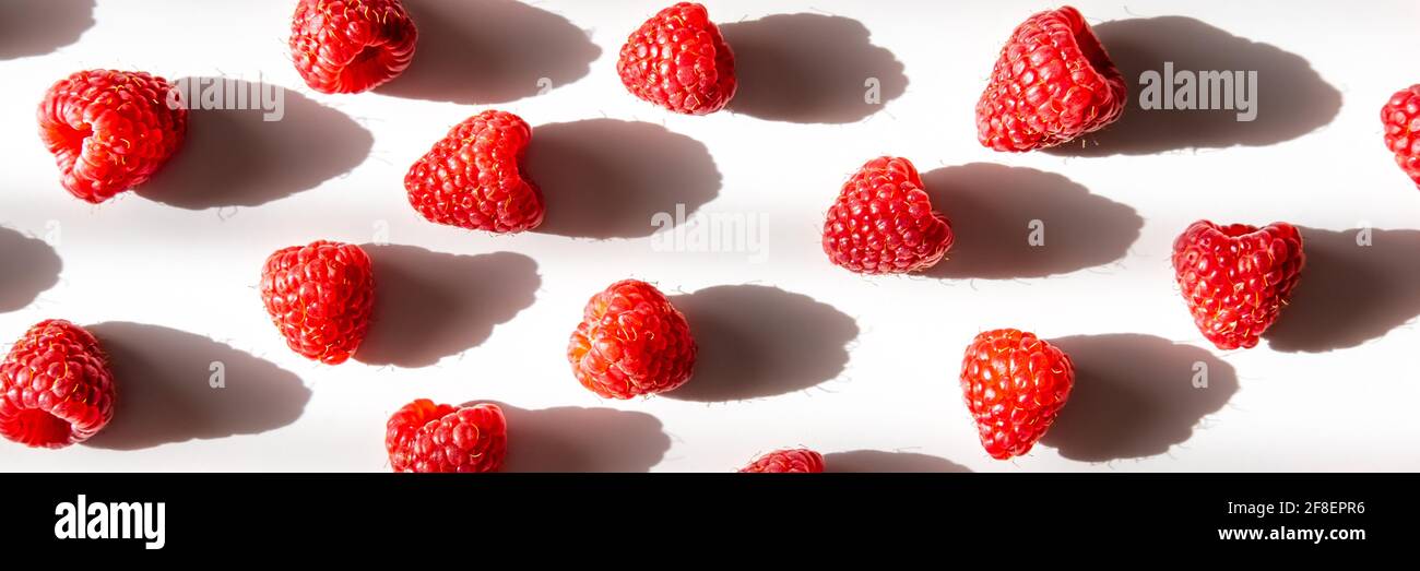 Pattern of fresh raspberry with shadow on light background. Flat lay. Banner. Stock Photo
