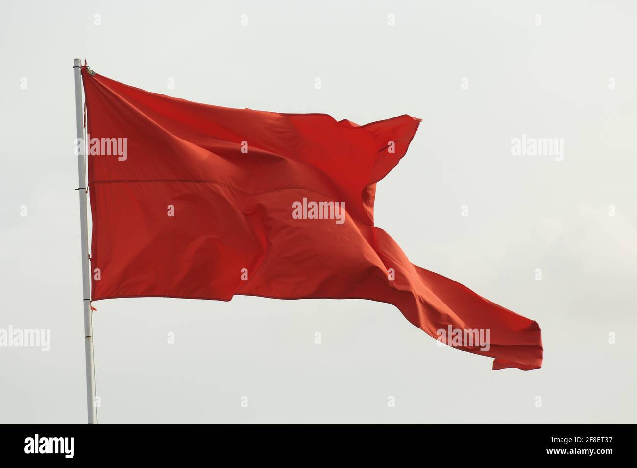 Red Flag Blowing in the Wind Stock Photo