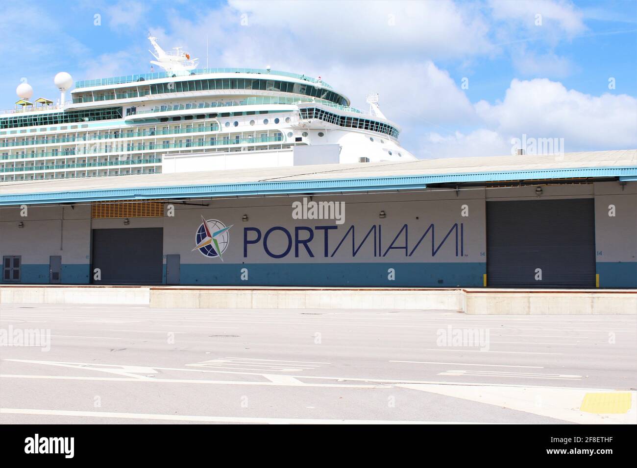 Port of Miami sign on a building where a large cruise ship is parked behind. Cruises have not been operating since the COVID-19 pandemic. Stock Photo