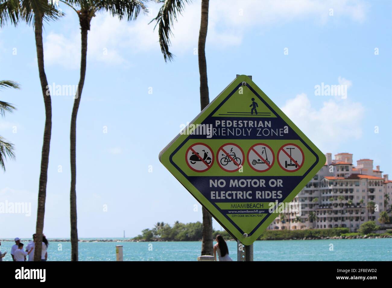 USA: Pedestrian friendly zone sign, no motor or electric rides at South Pointe beach in Miami Beach, Florida with a view of Palazzo Del Sol condominium Stock Photo