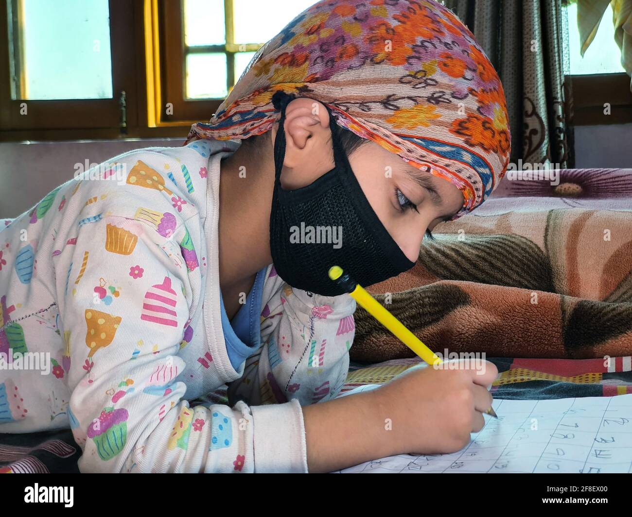 Masked School students are doing home work in home in covid-19 Stock Photo