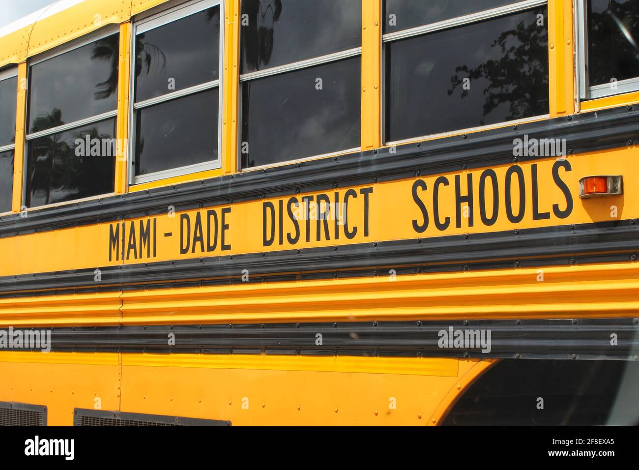 Yellow school bus from Miami Dade county public school system parked in a parking lot. South florida schools. Stock Photo
