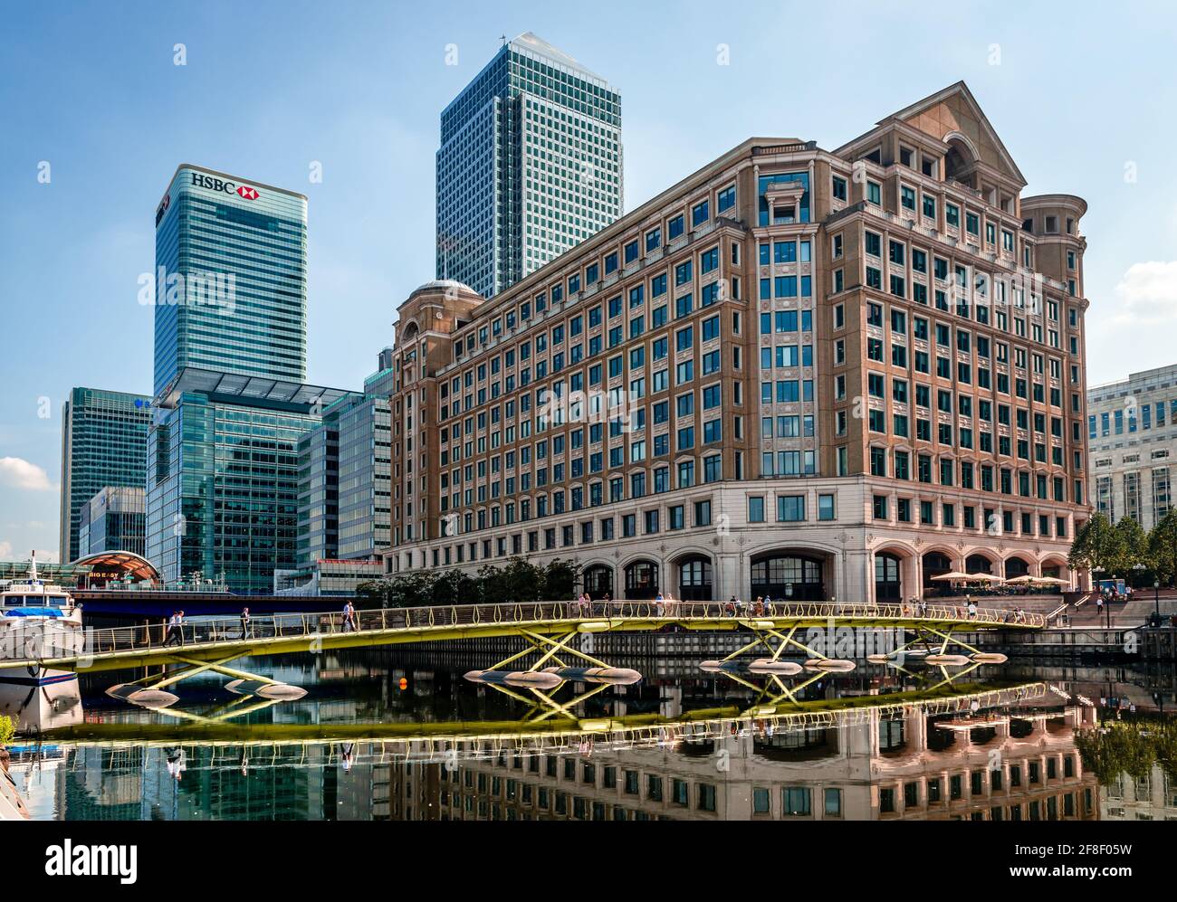 View of 8 Canada Square and One Canada Square Towers with the North Dock Pedestrian Bridge reflected on water, in Canary Wharf Estate. Stock Photo