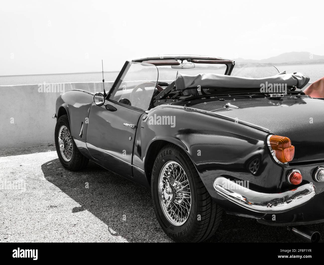 Black and White with partial red colour image of a Triumph Spitfire. ..A classic English convertible sports car Stock Photo