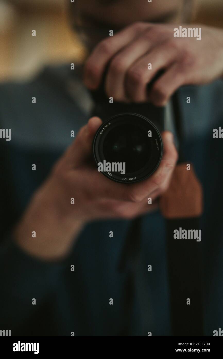 Shallow focus shot of a male photographer adjusting the focus of his ...