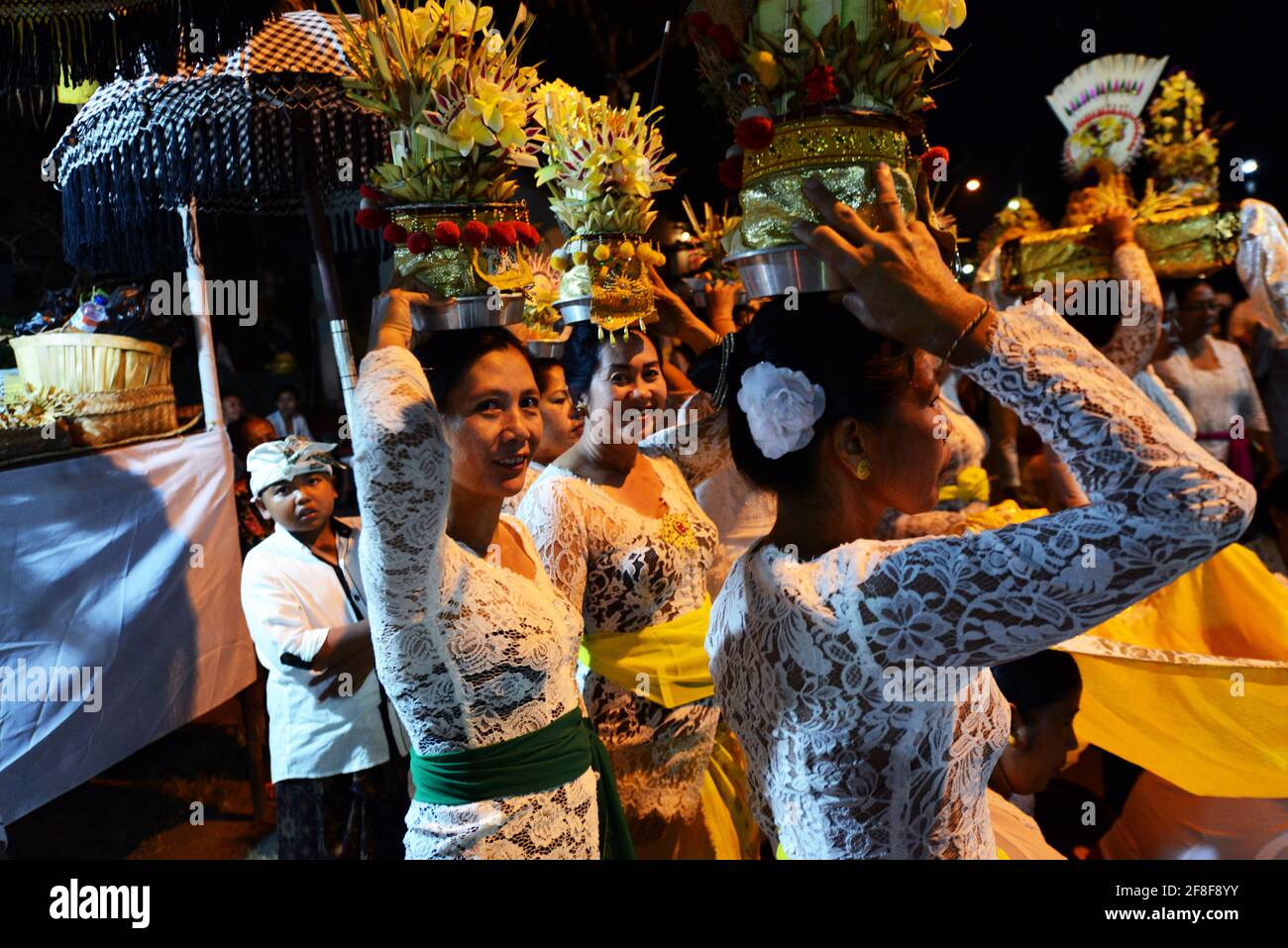 Balinese women carrying temple offerings on their head during a