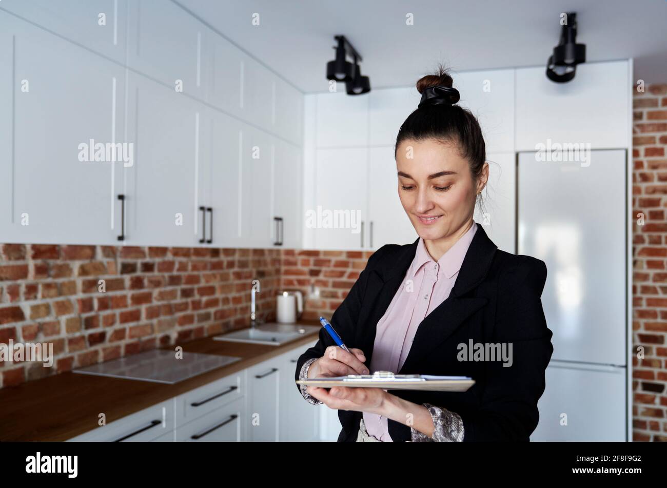 Real estate agent fills out documents in a new apartment Stock Photo
