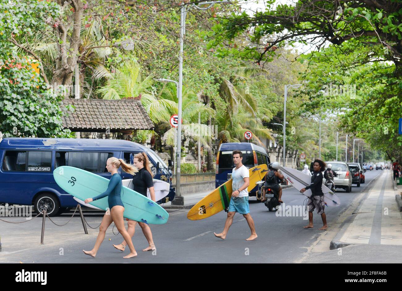 Tourist heading to the beach with their surfing boards in Kuta, Bali