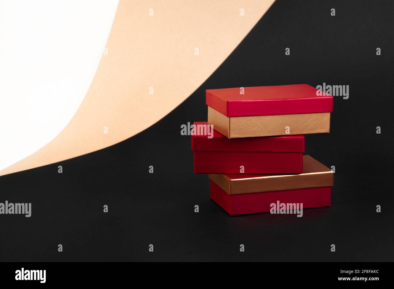 a tower of three golden-red boxes on a background of beige, black, and ...