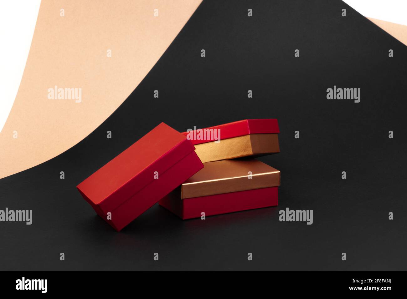 a pile of three golden-red boxes on a background of beige, black, white ...