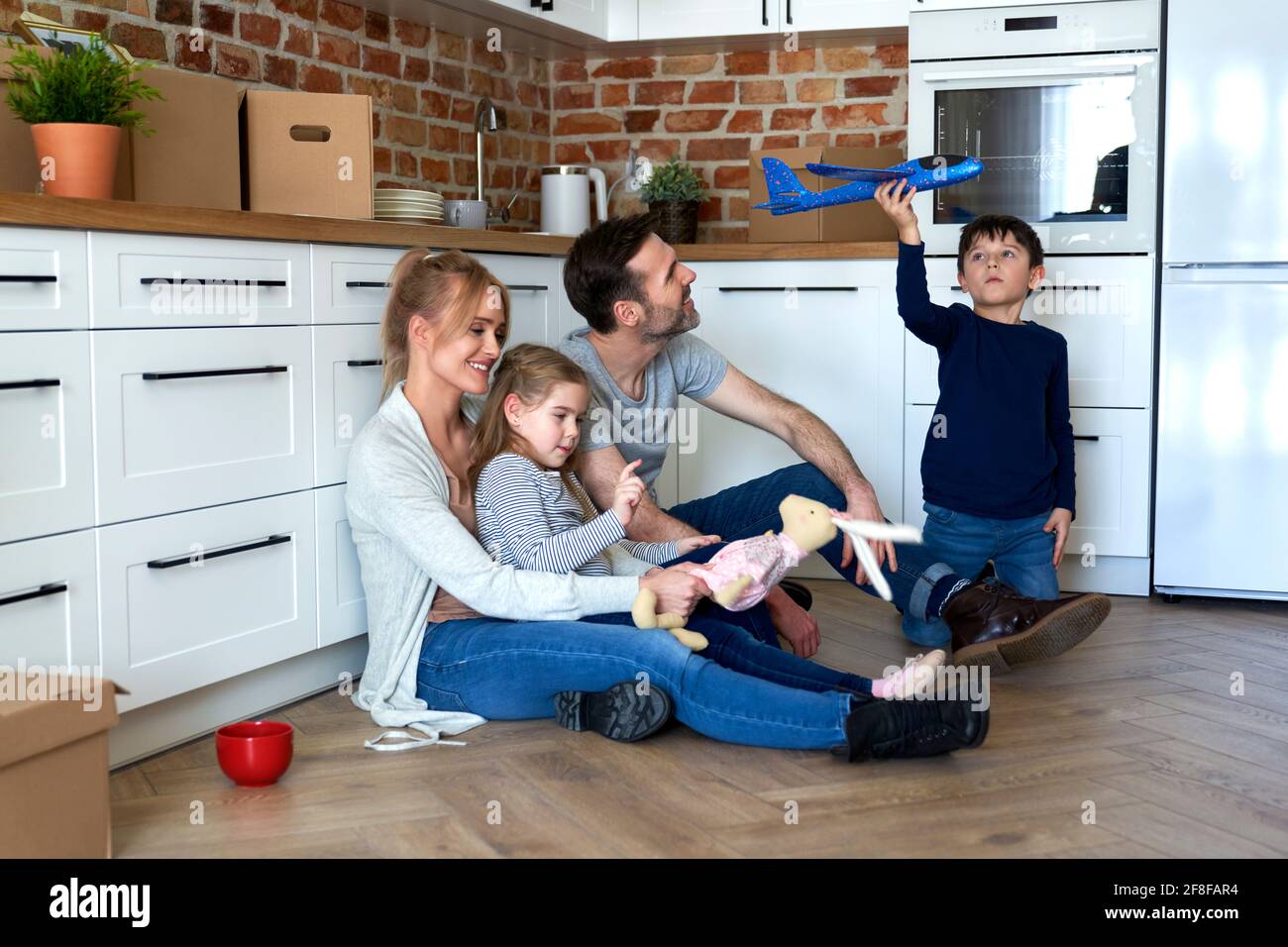 Happy family sitting during moving to a new home Stock Photo