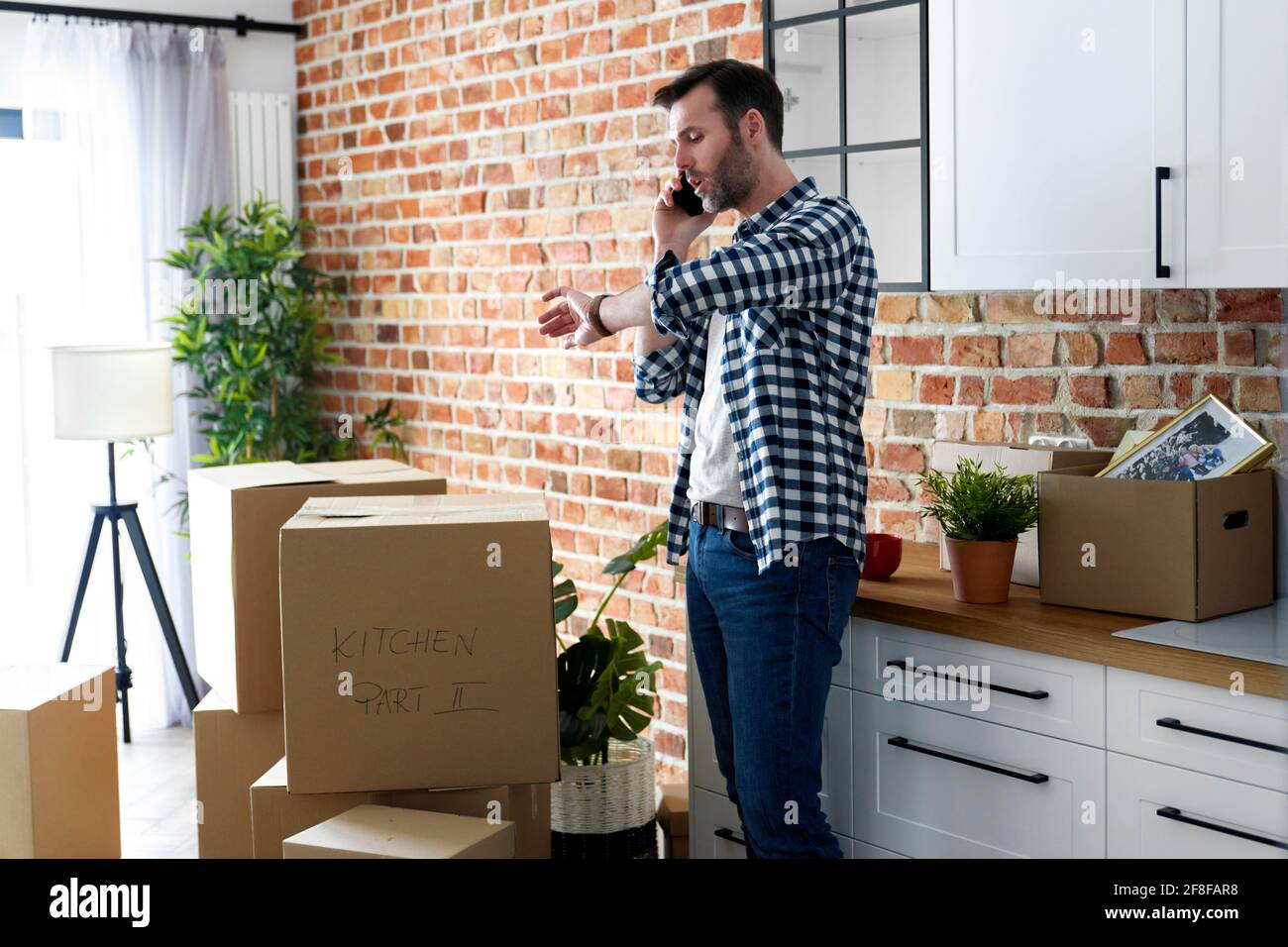 Displeased man calling for help with moving house Stock Photo