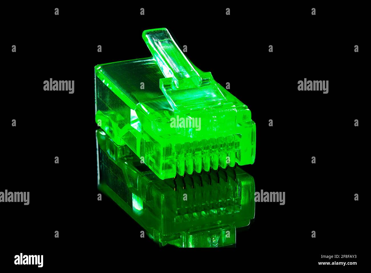 Connector rj-45. Neon green transparent connector rj45 for network and internet. Close up macro on black background with reflection, full depth of fie Stock Photo