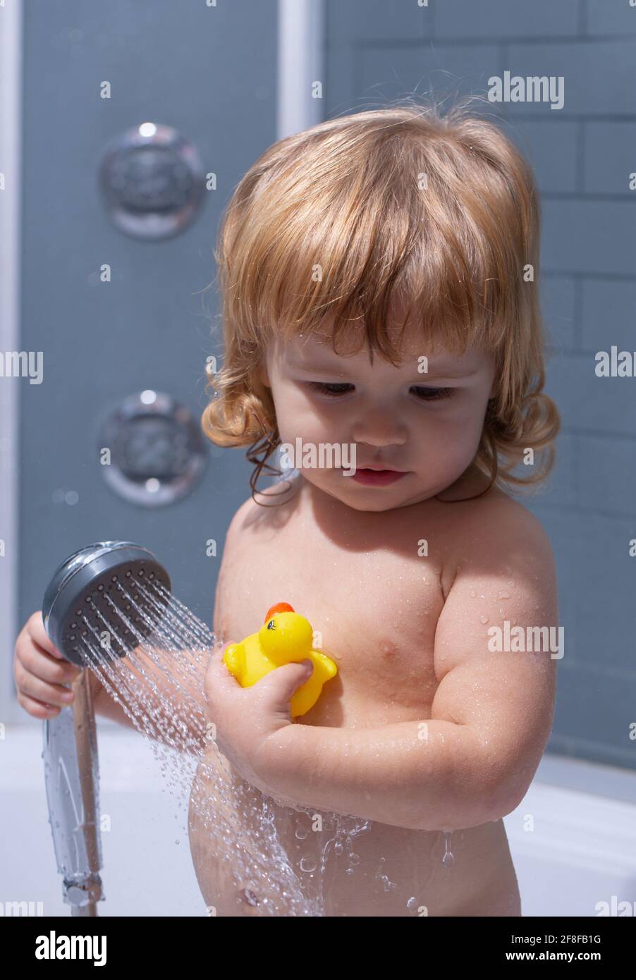Little child bathing in soapsuds. Washing adorable baby in bathroom. Kid with soap suds on hair