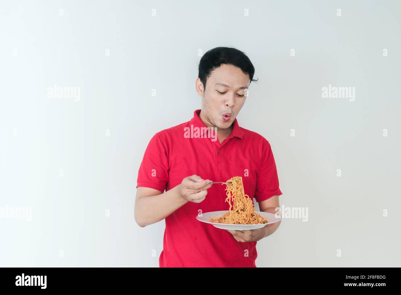 Portrait of Shock and Wow Young Asian man enjoy noodles. Eating lunch concept. Stock Photo