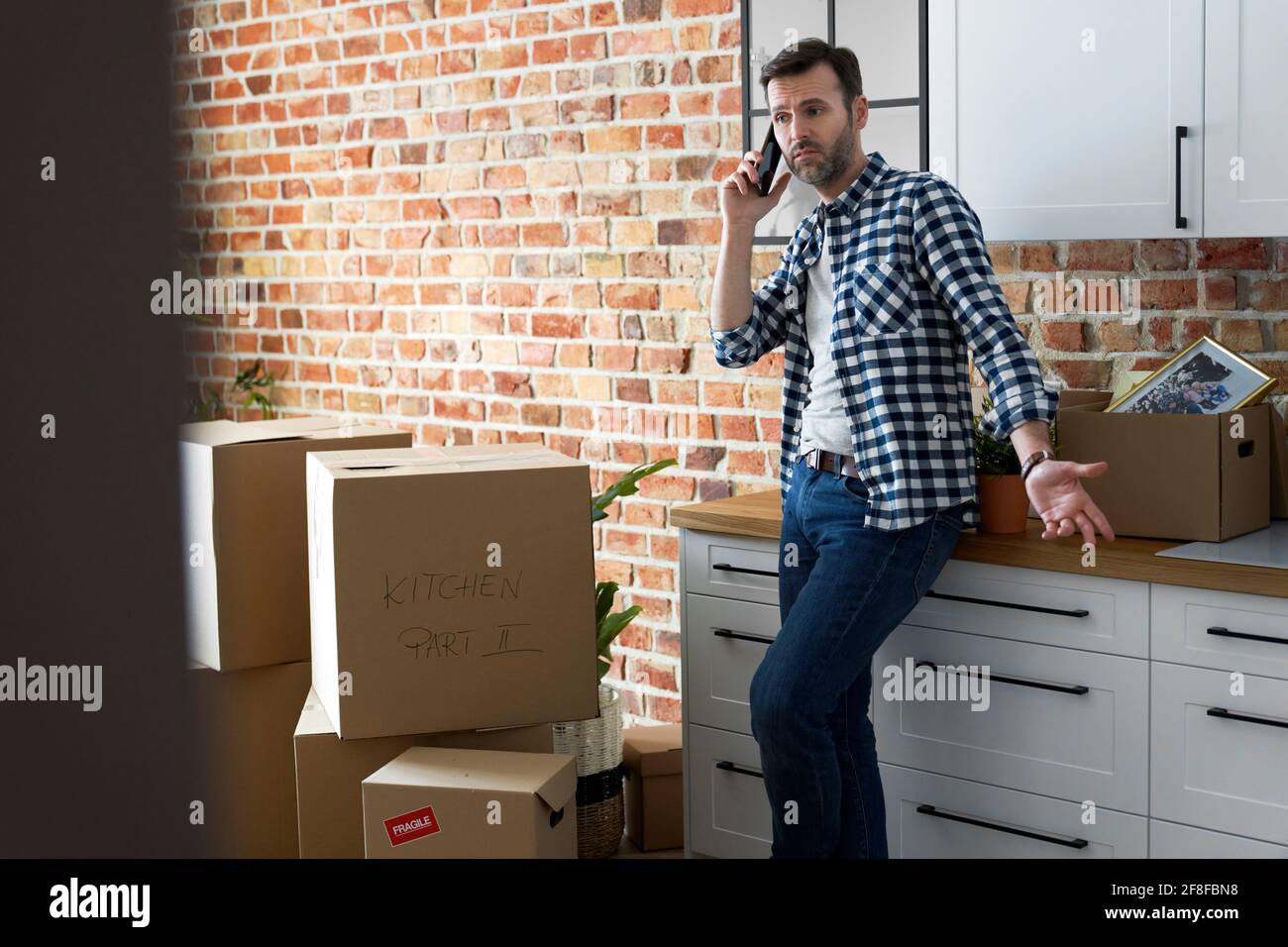 Displeased man calling during moving house Stock Photo