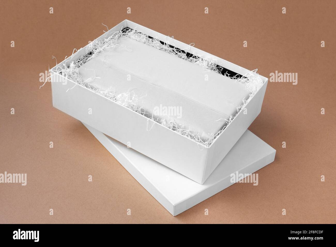 Download Top View Mockup A White Open Box With Clothes In A Clean Blank White Tissue Paper And Shredded Paper For Protection On A Beige Paper Background Stock Photo Alamy
