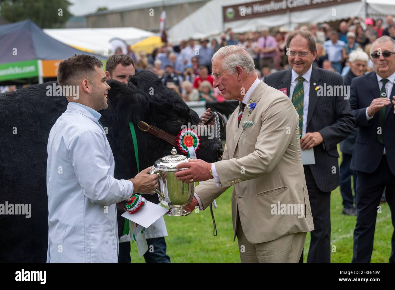 HRH Prince of Wales presenting a trophy to the owners of the champion Welsh Black cattle at the Royal Welsh Show in 2019. Stock Photo