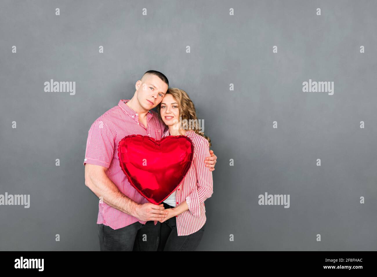Beautiful couple holding heart balloon in their hands Stock Photo - Alamy