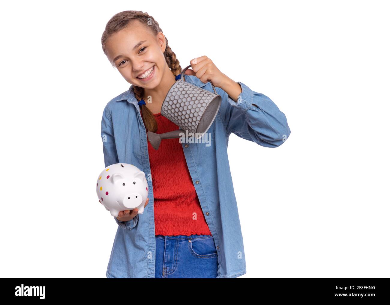Beautiful teenage girl holds a piggy bank in her hands, isolated on ...