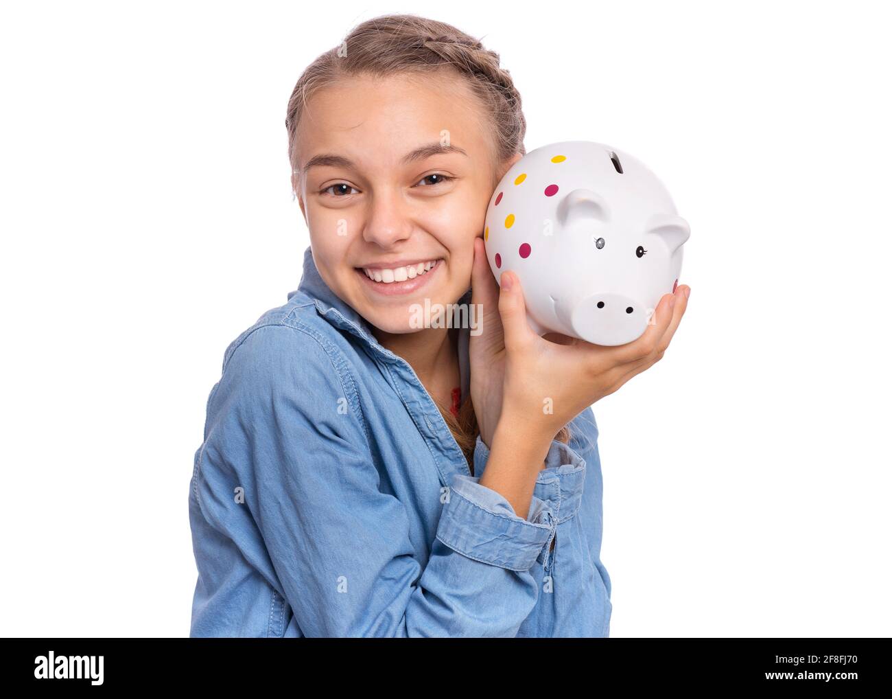 Beautiful teenage girl holds a piggy bank in her hands, isolated on ...