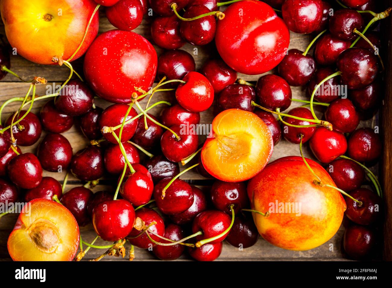 Ripe plums, nectarines and cherries in rustic pan. Selective focus. Stock Photo