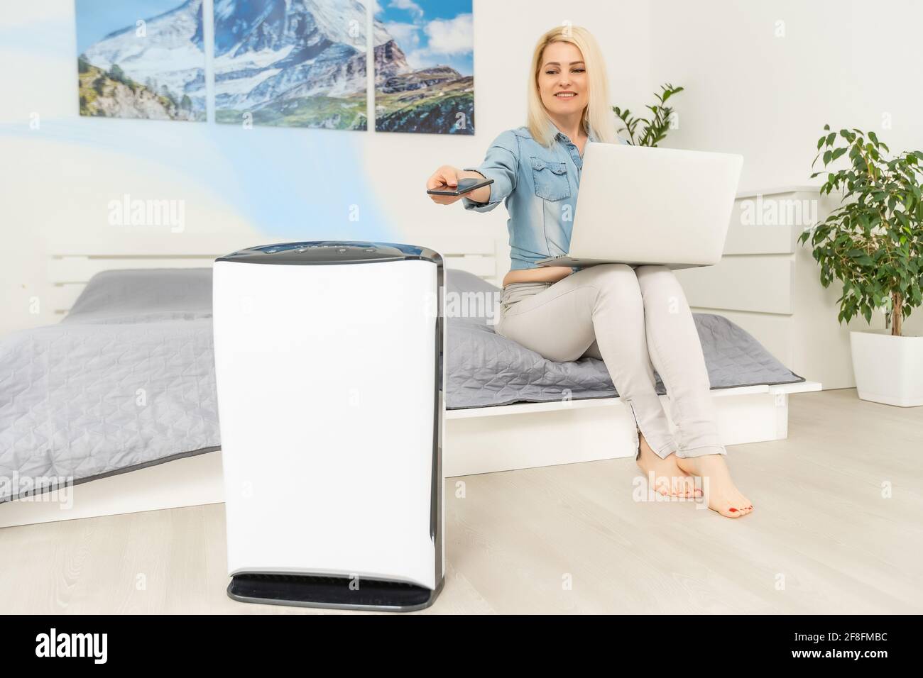 woman turns on the air purifier Stock Photo Alamy