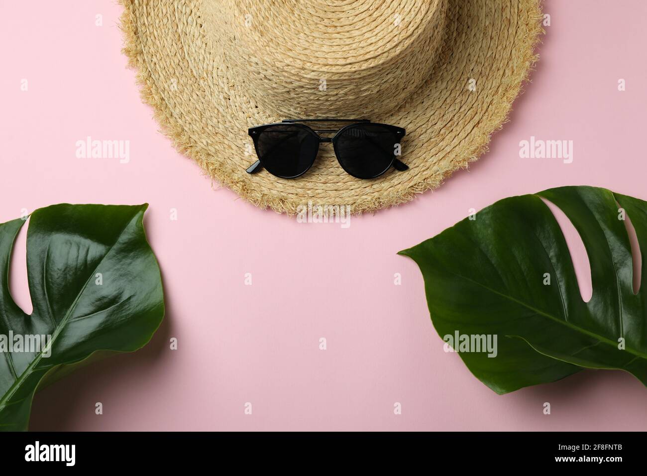 Straw hat, palm leaves and sunglasses on pink background Stock Photo ...
