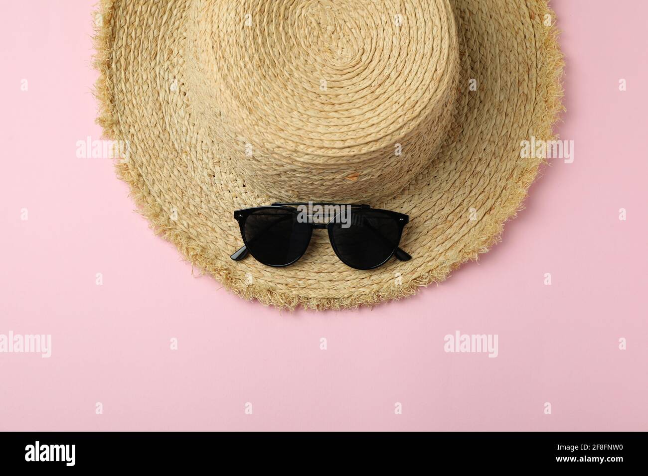 Straw hat and sunglasses on pink background Stock Photo - Alamy